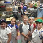 Junior Girl Scouts working at a local bakery.