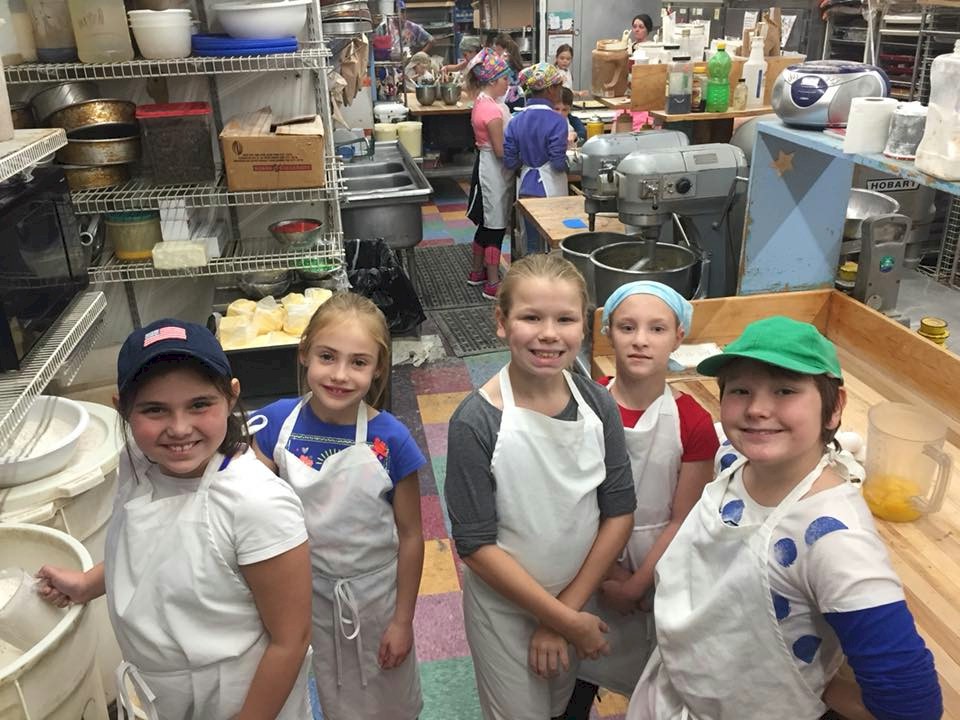 Junior Girl Scouts working at a local bakery.