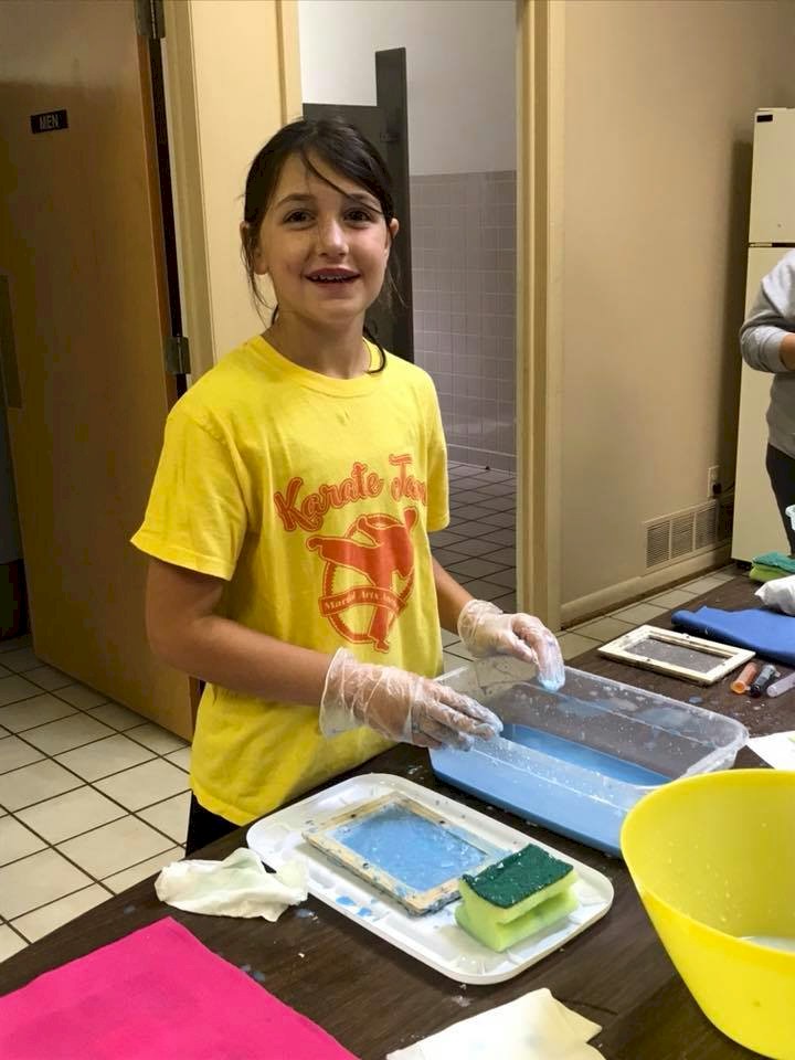 Cadette Girl Scout making paper.