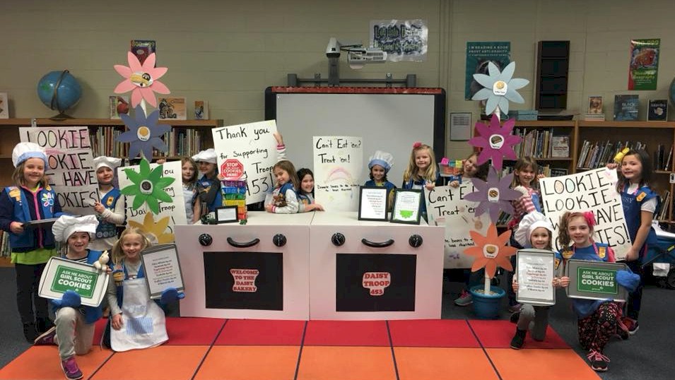 Daisy Girl Scouts bling their cookie booth.
