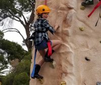 Don't forget your cowboy boots when you earn your rock climbing patch! One of the Risk takers from Brownie troop 9095 on the rock climbing wall.