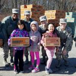 Brownie Girl Scouts donating cookies to the military