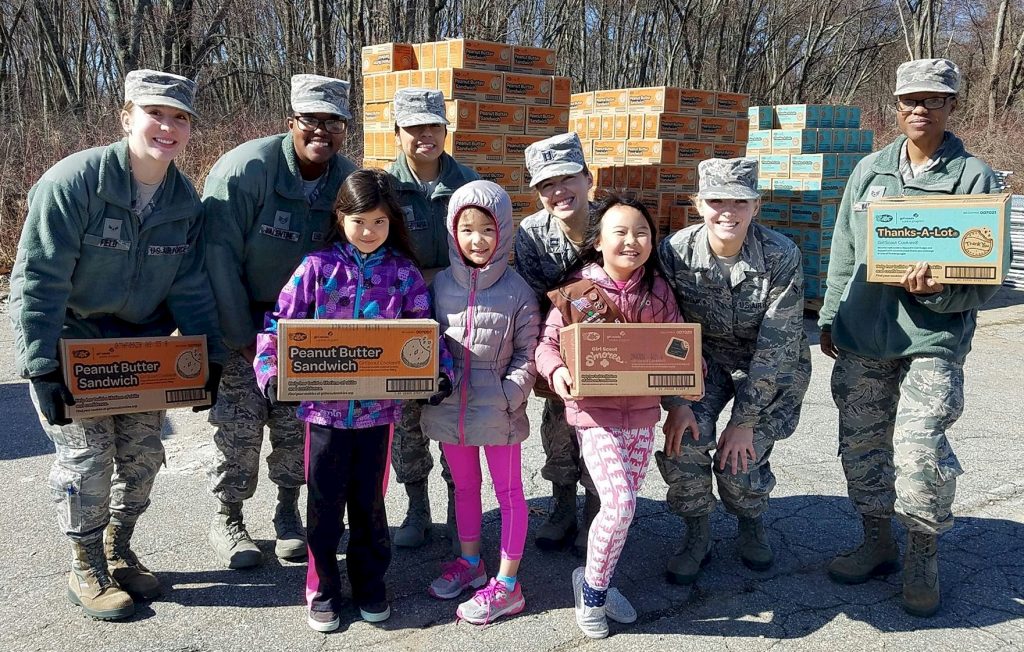 Brownie Girl Scouts donating cookies to the military