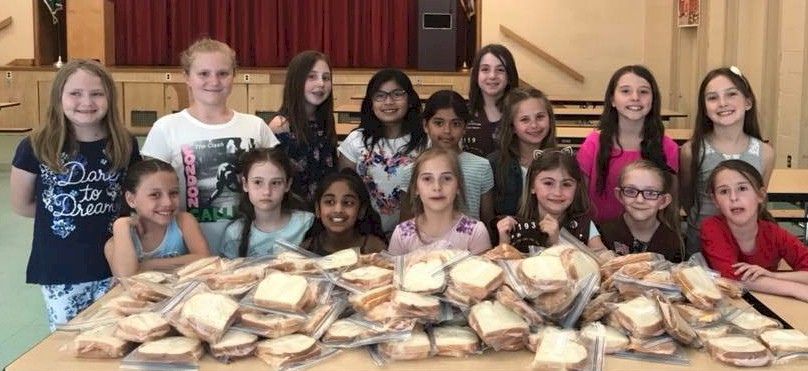 Girl Scout Brownies make sandwiches for the local soup kitchen.