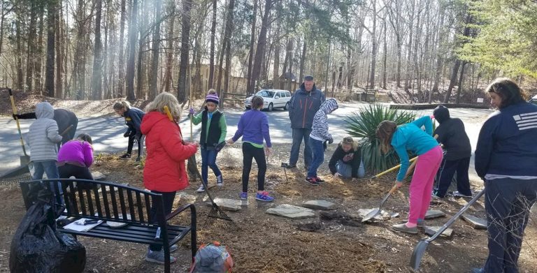 Girl Scouts enhancing a butterfly garden.