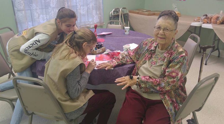 Girl Scouts give manicures at the retirement center.