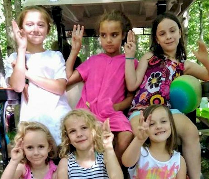 Daisy Girl Scouts showing the promise sign.