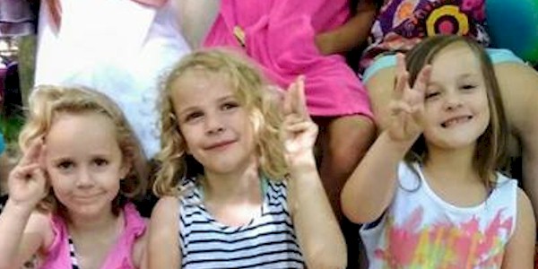 Daisy Girl Scouts showing the promise sign.