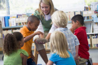 Kindergarten teacher and children looking at bird's nest in libr Preschool Advocates